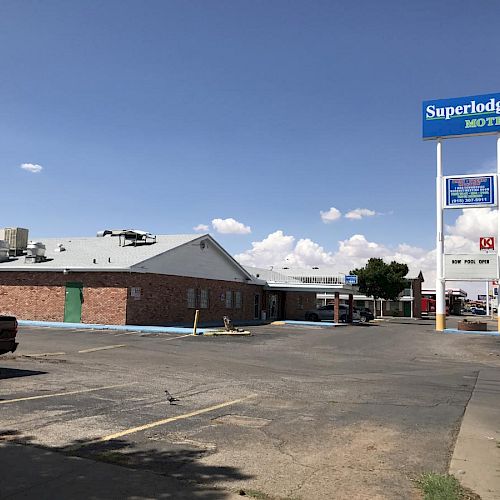 The image shows a Superlodge hotel with a parking lot and a large sign in the foreground.